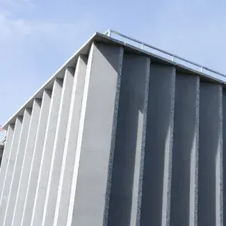 Exterior of a modern stone building against a blue sky.